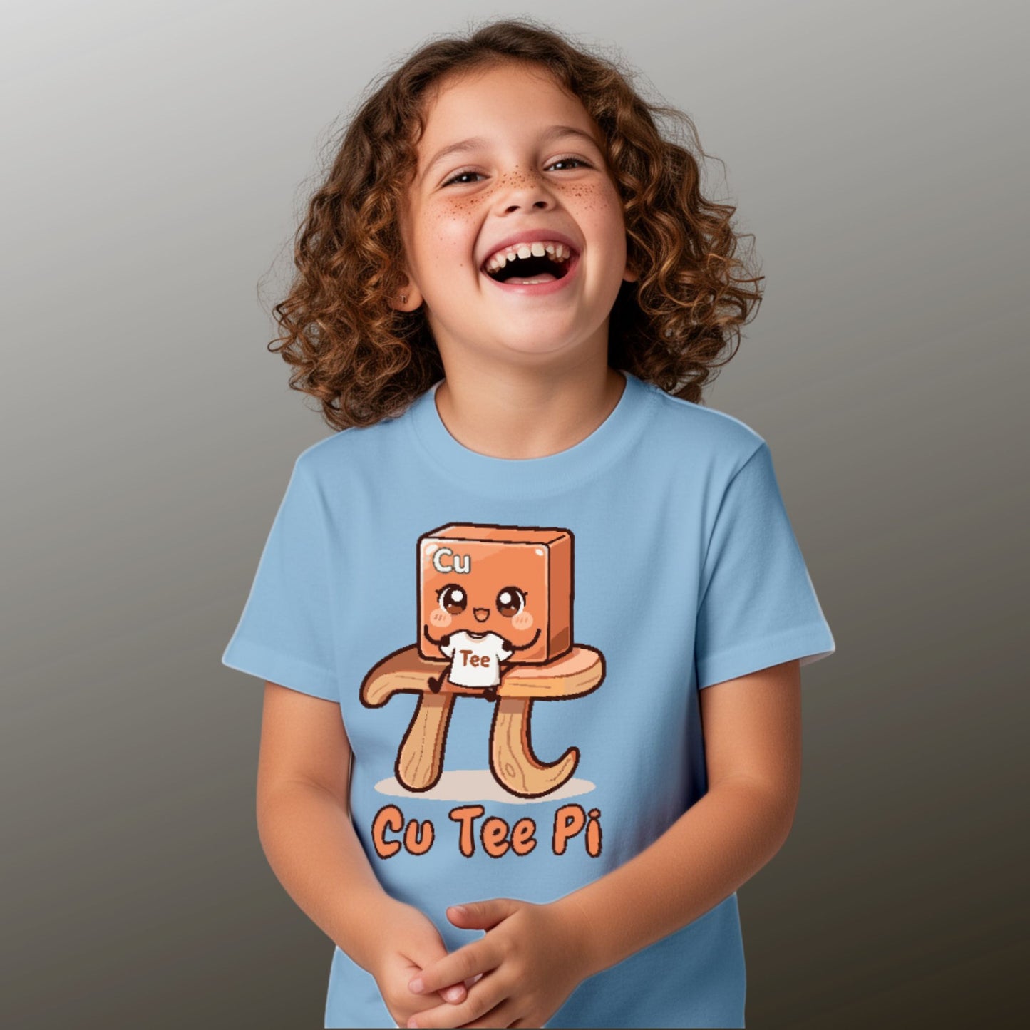 girl wearing blue Cu Tee Pi kids science t-shirt with cute copper cube sitting on pi symbol table