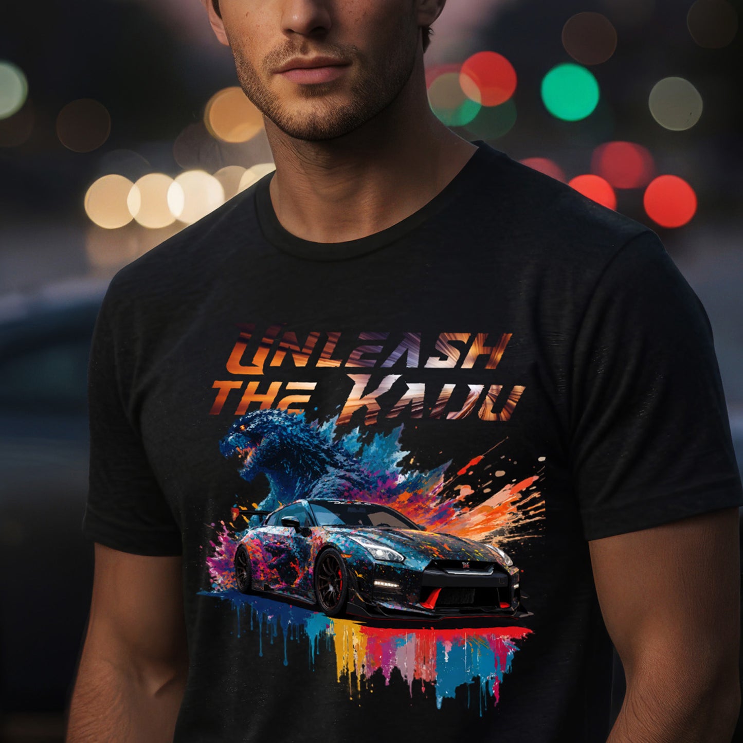 Man wearing a black t-shirt with nissan gtr35 with godzilla design and text 'UNLEASH THE KADO' against a blurred lights background