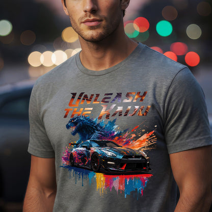 Man wearing a gray t-shirt with nissan gtr35 with godzilla design and text 'UNLEASH THE KADO' against a blurred lights background