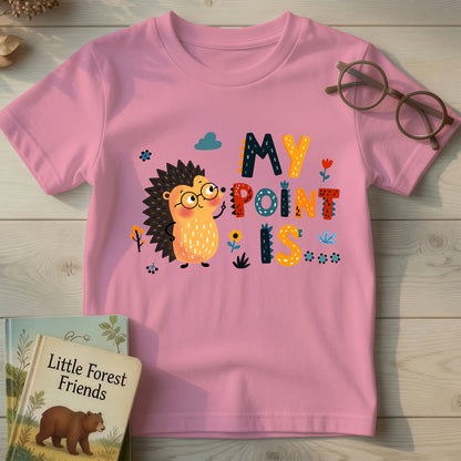 Pink kids t-shirt with cartoon hedgehog in glasses and "My Point Is" quill-textured typography, flat lay on wood background